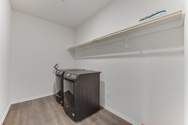 washroom with independent washer and dryer, wood finished floors, baseboards, and laundry area