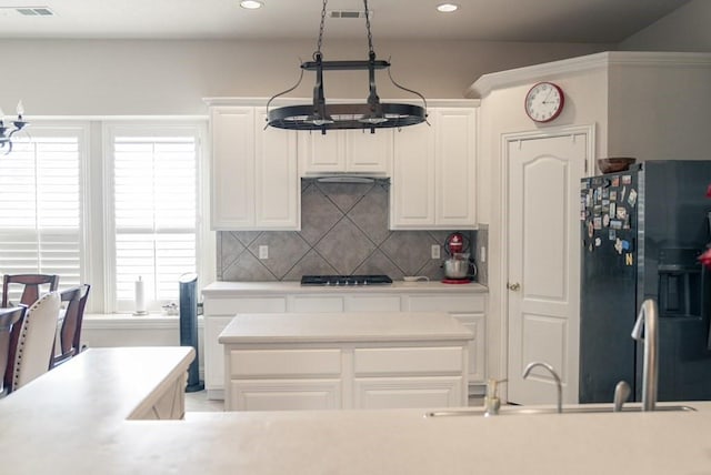 436 Dakota Dr, Murphy, TX 75094 - kitchen featuring black fridge, tasteful backsplash, light countertops, white cabinets, and recessed lighting