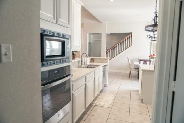 436 Dakota Dr, Murphy, TX 75094 - kitchen with appliances with stainless steel finishes, a sink, light countertops, white cabinets, and light tile patterned flooring