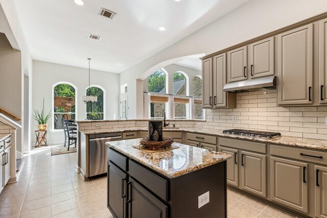 kitchen featuring stainless steel appliances, a sink, tasteful backsplash, visible vents, and under cabinet range hood