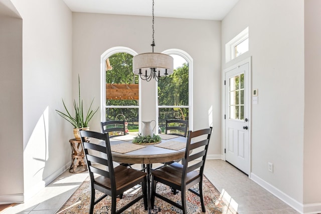 dining room with baseboards, light tile patterned floors, and an inviting chandelier