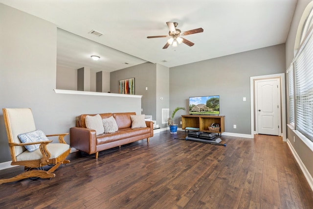 living room featuring a high ceiling, visible vents, a ceiling fan, wood-type flooring, and baseboards