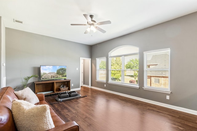 living area featuring baseboards, wood finished floors, visible vents, and ceiling fan