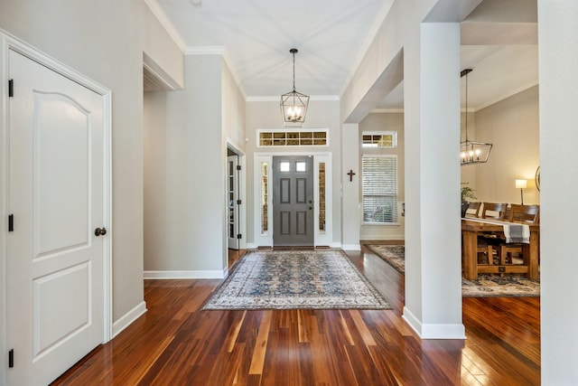 foyer entrance with wood-type flooring, an inviting chandelier, and crown molding