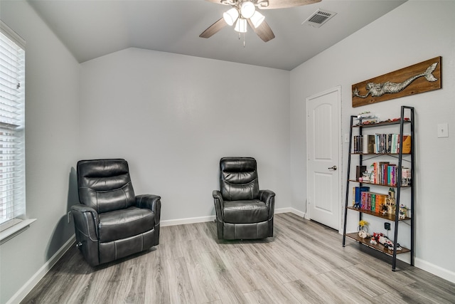 sitting room with a healthy amount of sunlight, vaulted ceiling, visible vents, wood finished floors, and ceiling fan