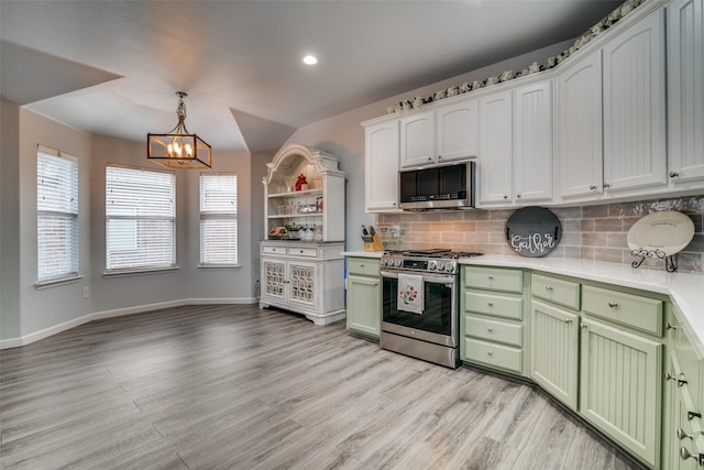 kitchen featuring a chandelier, backsplash, green cabinetry, and stainless steel appliances