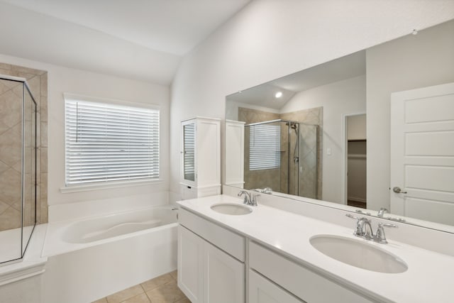 bathroom with a sink, double vanity, a stall shower, and a garden tub
