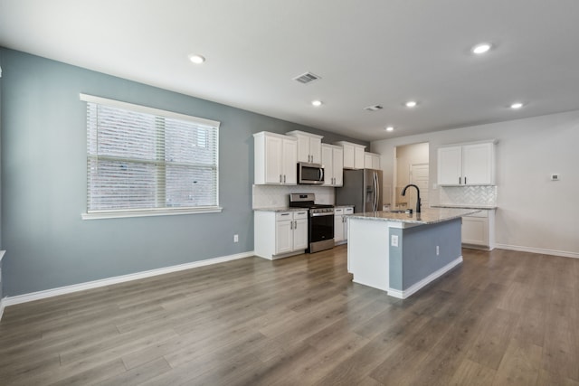kitchen with a sink, backsplash, stainless steel appliances, and visible vents