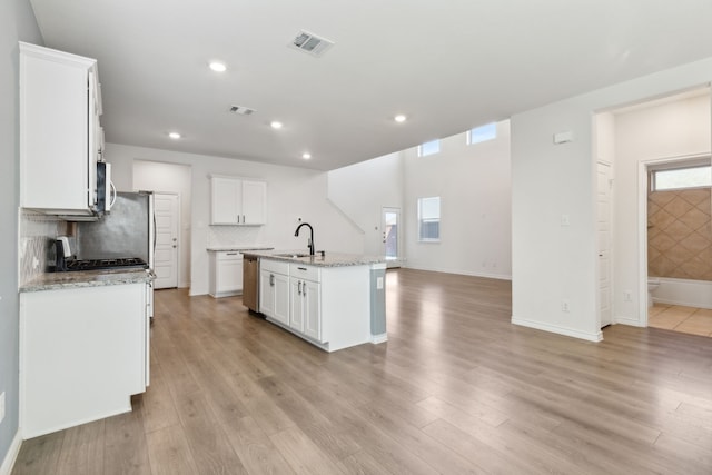 kitchen featuring visible vents, stainless steel dishwasher, recessed lighting, white cabinets, and tasteful backsplash