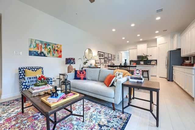 living area with recessed lighting, a ceiling fan, visible vents, and light wood-type flooring