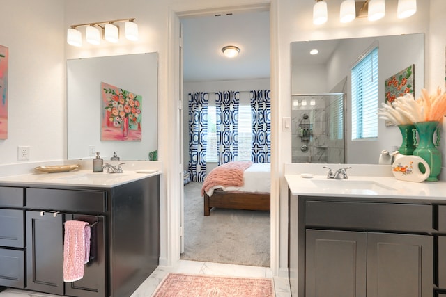 ensuite bathroom with a sink, tile patterned floors, a shower stall, and two vanities