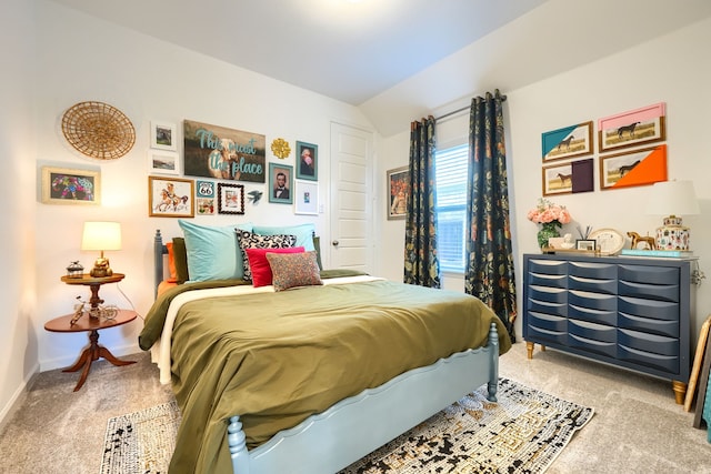 carpeted bedroom featuring baseboards and vaulted ceiling