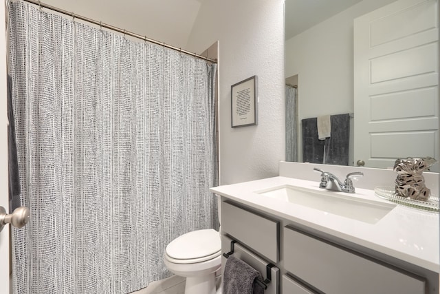bathroom featuring vanity, a textured wall, toilet, and curtained shower