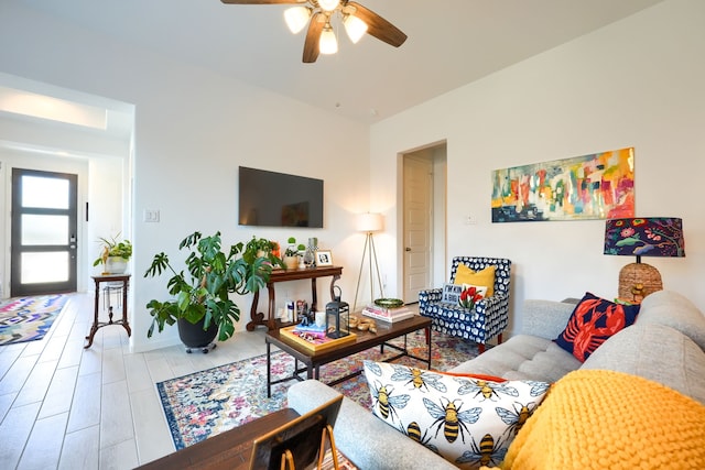 living area featuring baseboards and a ceiling fan