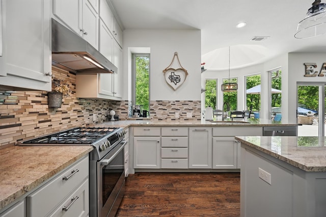 kitchen with under cabinet range hood, visible vents, a sink, a peninsula, and appliances with stainless steel finishes