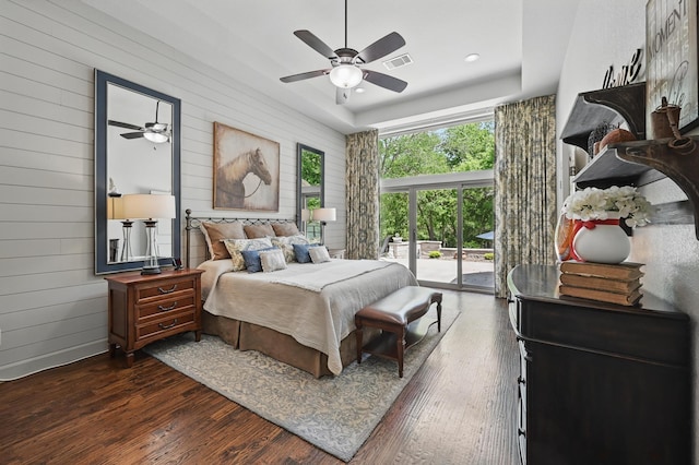 bedroom featuring recessed lighting, dark wood finished floors, wooden walls, access to exterior, and visible vents