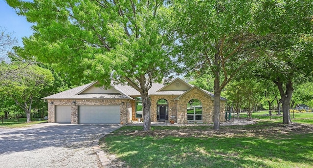 view of front of home featuring brick siding, an attached garage, driveway, and a front lawn