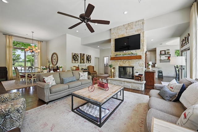 living area featuring a fireplace, wood finished floors, recessed lighting, and ceiling fan with notable chandelier