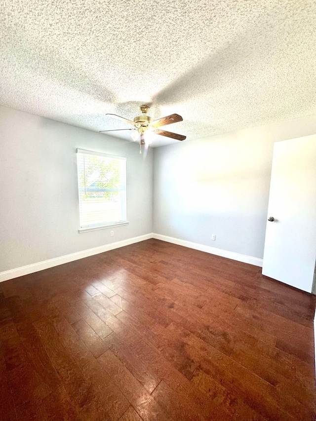 unfurnished room featuring baseboards, wood finished floors, a textured ceiling, and ceiling fan