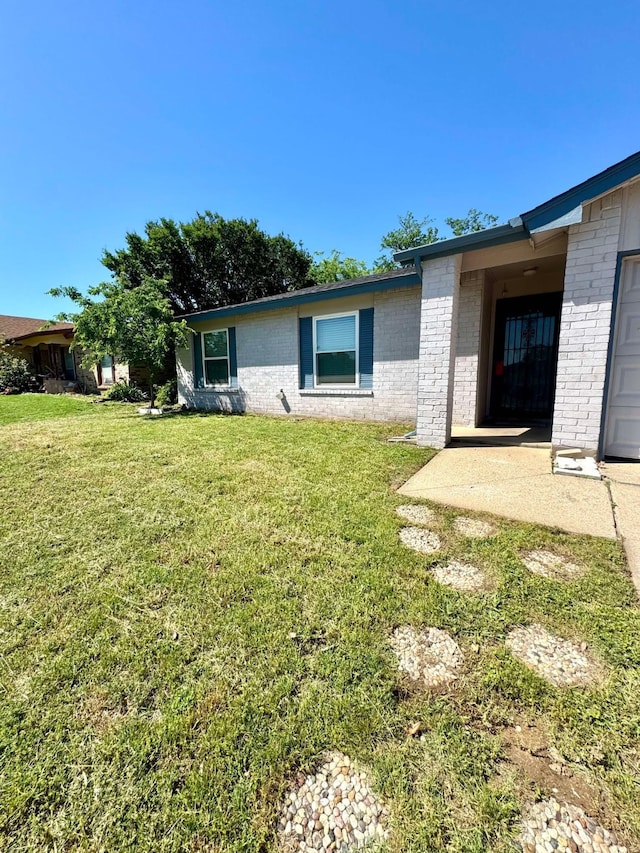 exterior space with a lawn and brick siding