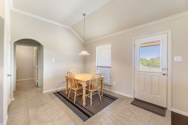 dining room featuring vaulted ceiling, crown molding, light tile patterned flooring, arched walkways, and baseboards