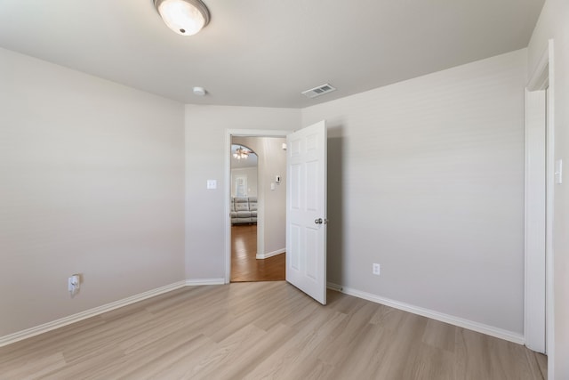 unfurnished bedroom with light wood-style flooring, visible vents, and baseboards