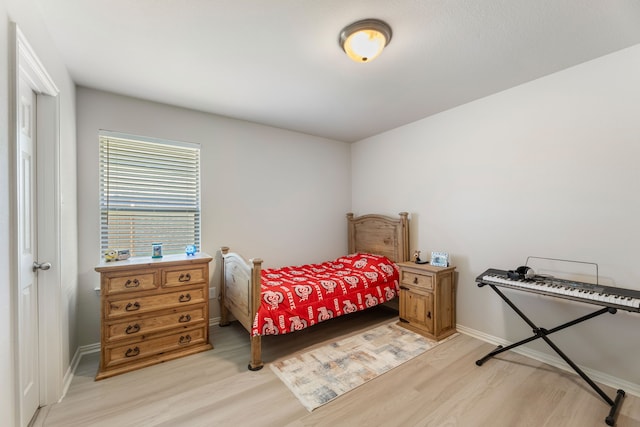 bedroom with light wood-style flooring and baseboards