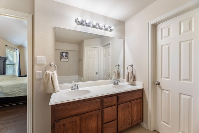 full bathroom with ensuite bath, a sink, and double vanity