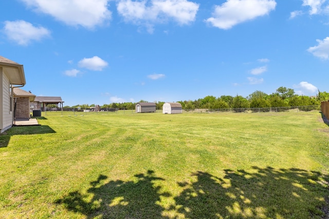 view of yard featuring a fenced backyard, an outdoor structure, and a storage shed