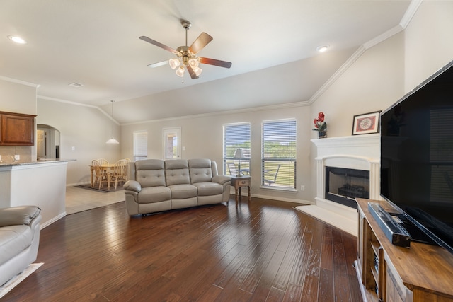 living area with arched walkways, dark wood finished floors, lofted ceiling, and ceiling fan