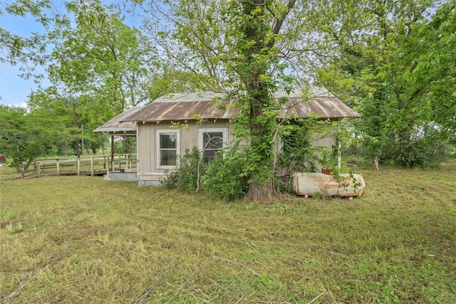 1605 Tyler St, Thornton, TX 76687 - rear view of property with a lawn, an outbuilding, metal roof, and fence