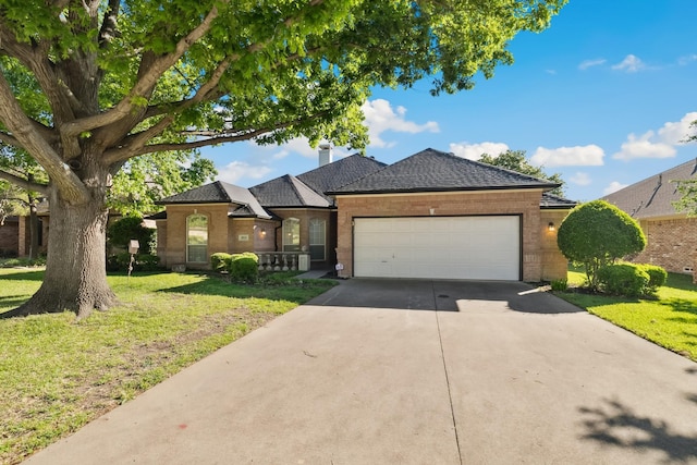 ranch-style home with a front lawn, driveway, brick siding, and a garage