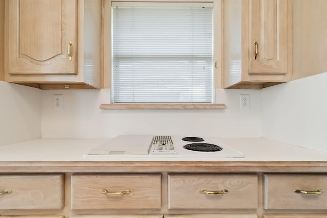 kitchen with white electric cooktop, light brown cabinets, and light countertops