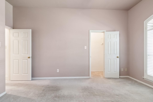 empty room with baseboards and light colored carpet