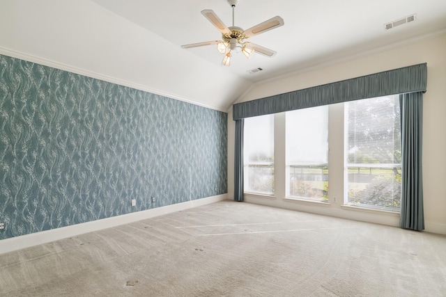 carpeted spare room featuring wallpapered walls, ceiling fan, baseboards, lofted ceiling, and visible vents