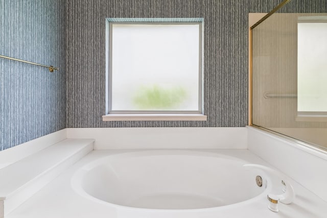bathroom with a bath and wallpapered walls