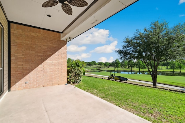 view of patio featuring view of golf course, a ceiling fan, and a water view