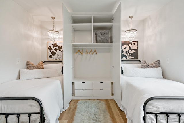 bedroom with light wood finished floors and a notable chandelier