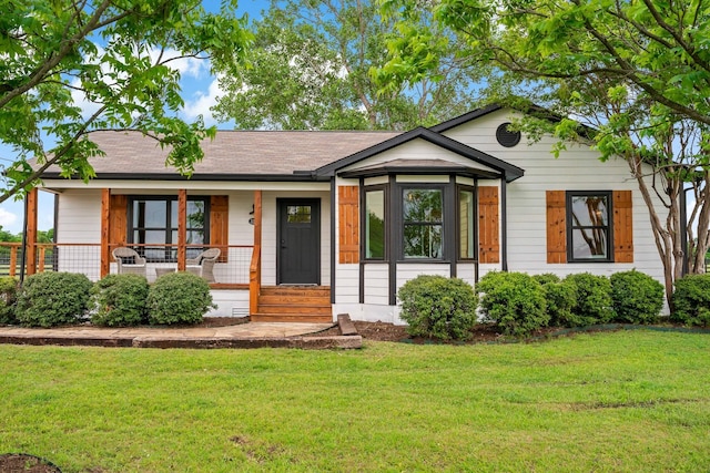 ranch-style home featuring covered porch and a front yard