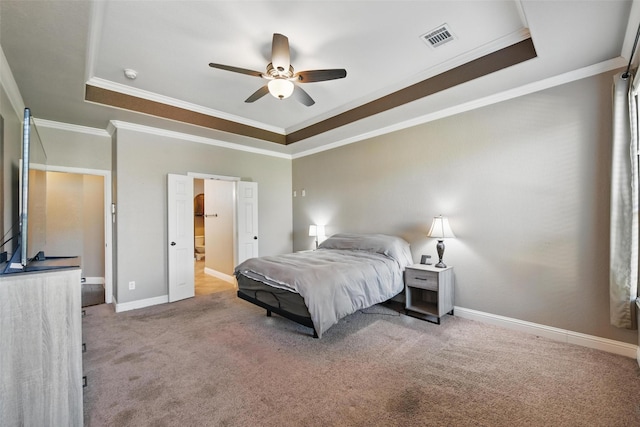 carpeted bedroom featuring a tray ceiling, visible vents, baseboards, a ceiling fan, and crown molding