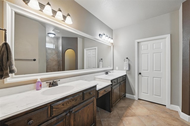 bathroom with baseboards, tile patterned flooring, and vanity