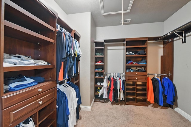 spacious closet with attic access, carpet floors, and visible vents