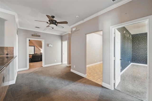 unfurnished living room featuring carpet, visible vents, a ceiling fan, ornamental molding, and baseboards