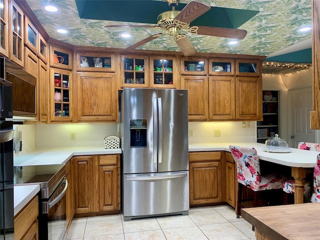 kitchen featuring ceiling fan, stainless steel fridge with ice dispenser, range with electric cooktop, and brown cabinets