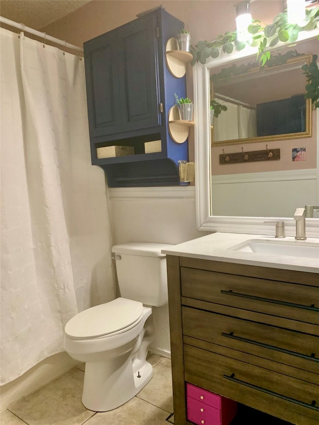 full bathroom with tile patterned floors, vanity, curtained shower, and toilet