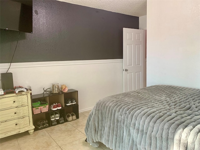 bedroom featuring a textured ceiling and light tile patterned floors