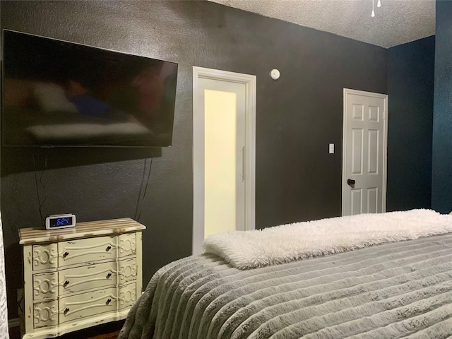 bedroom featuring a textured wall and a textured ceiling