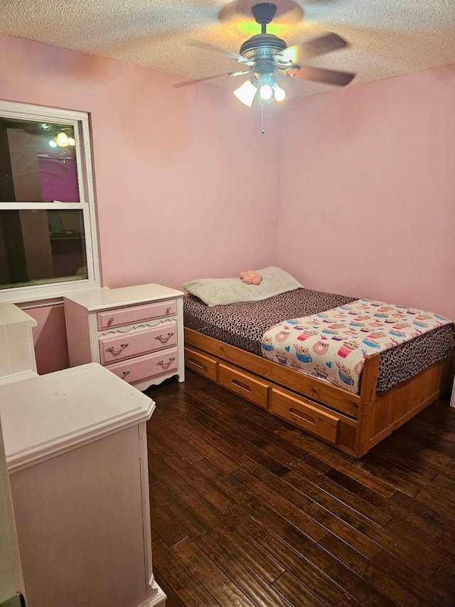 bedroom with dark wood finished floors, a ceiling fan, and a textured ceiling