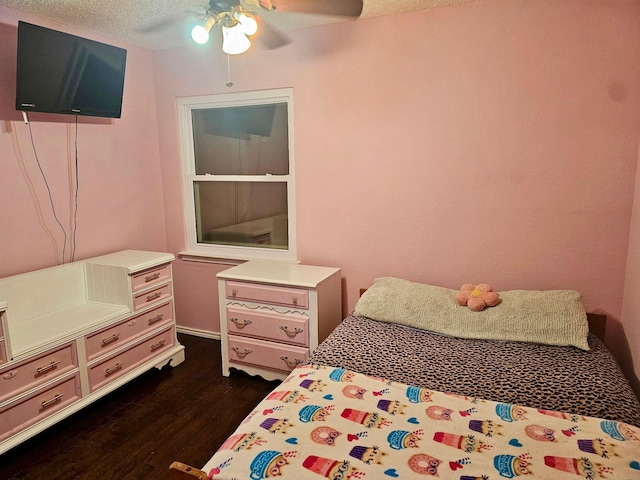 bedroom featuring ceiling fan, dark wood-style flooring, and a textured ceiling