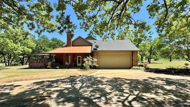 view of front of home with a front lawn, driveway, a chimney, metal roof, and an attached garage